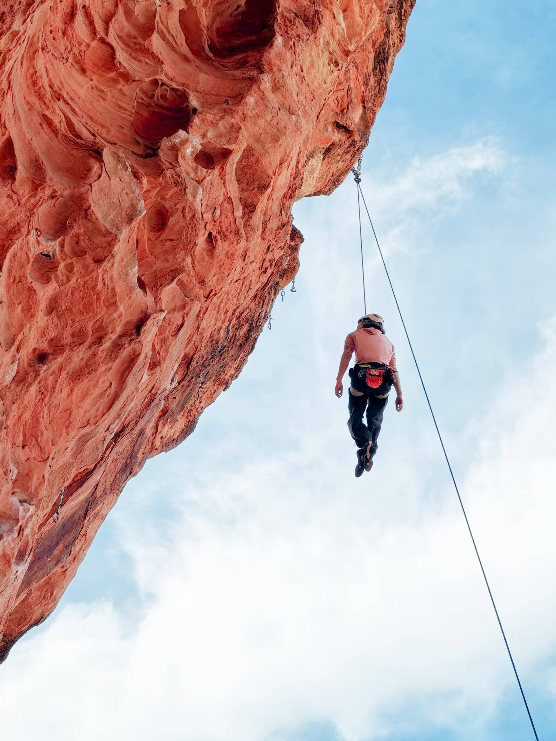 Climber suspended beside an overhanging sandstone wall