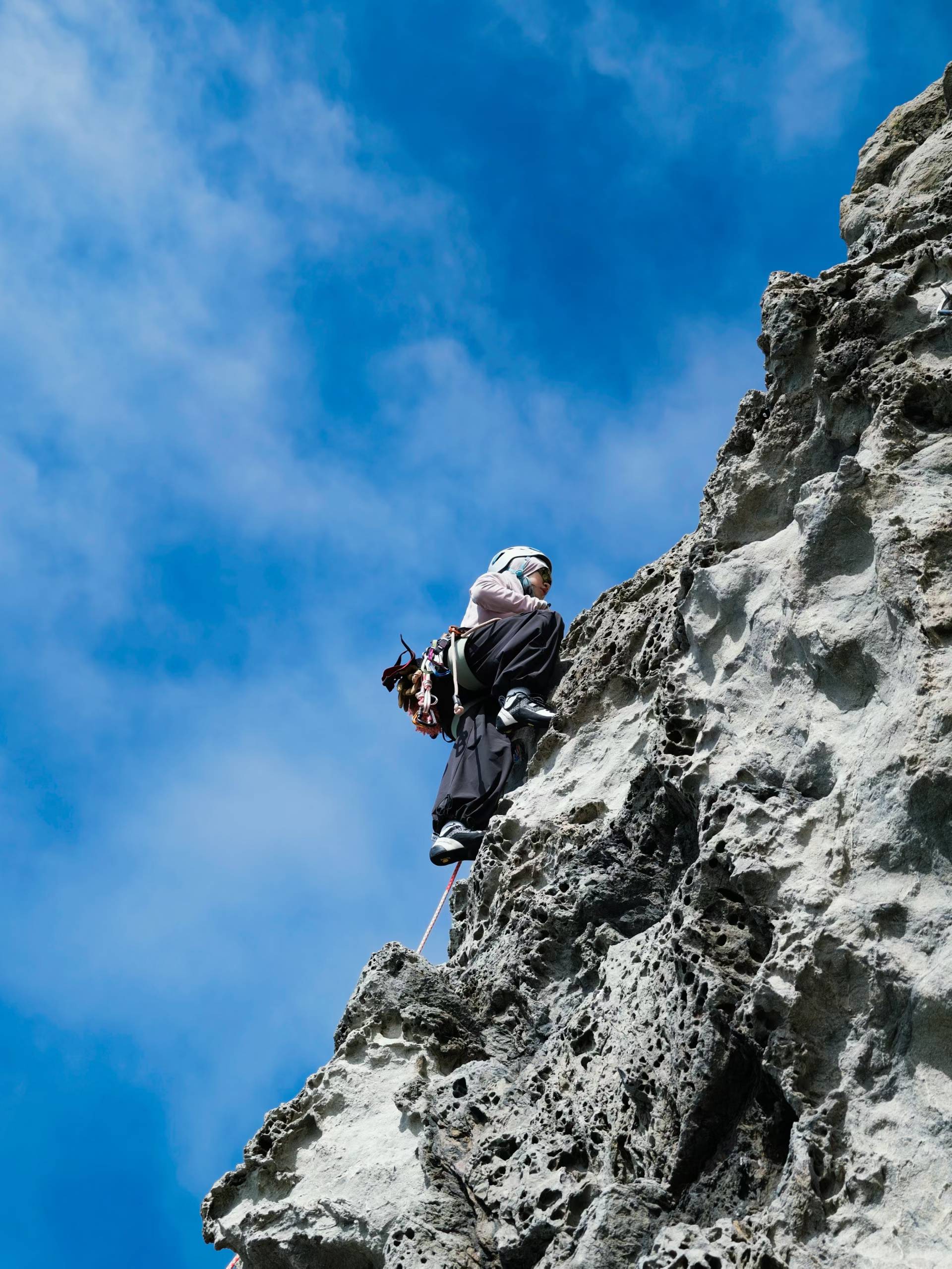 Climbing on gray rock under a blue sky