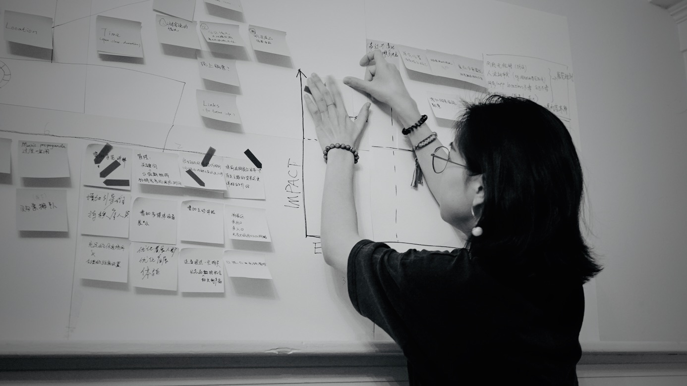 Original photograph of Carleen reviewing research notes on a whiteboard